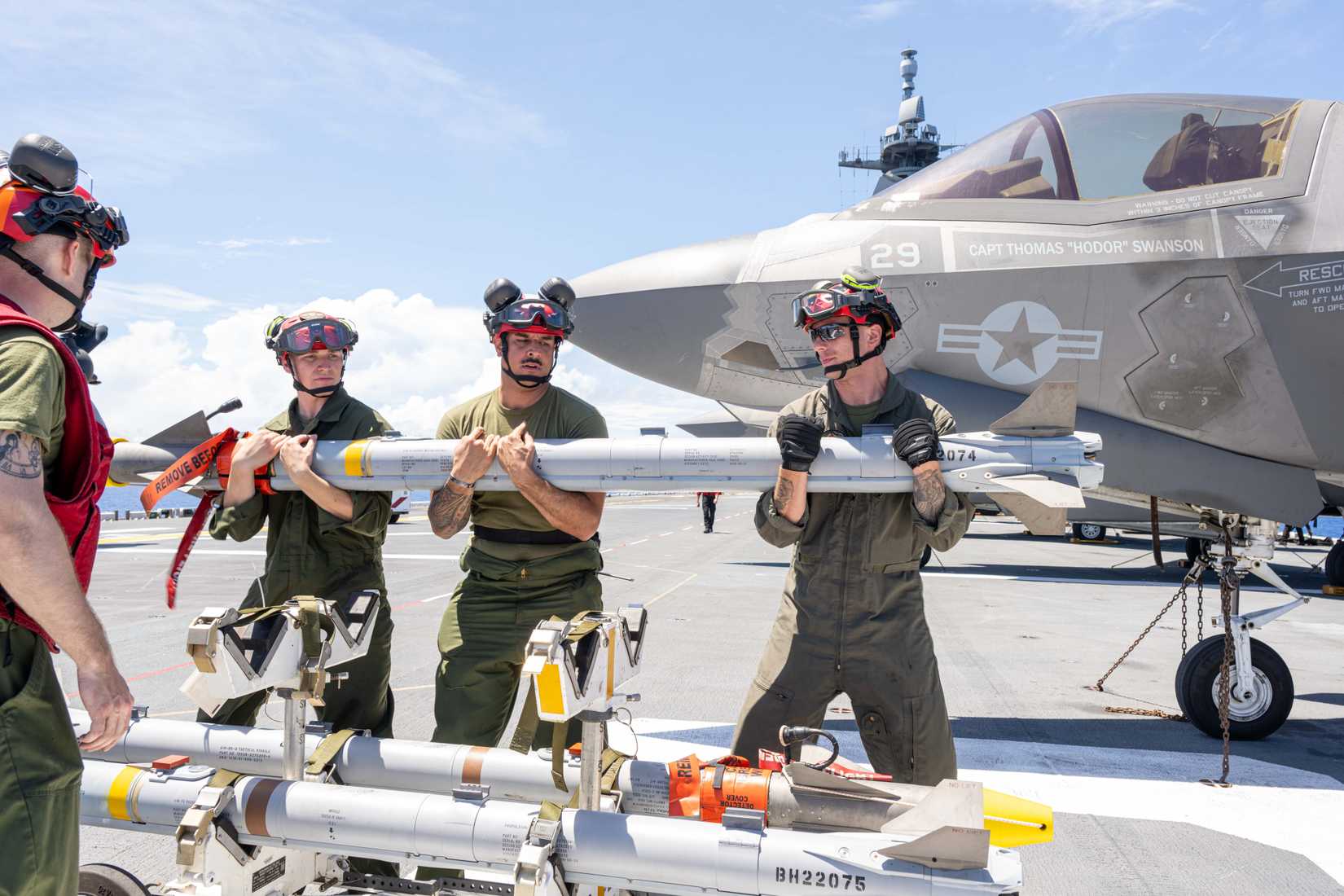 Marines load an AIM-9X missile on the flight deck of the forward-deployed amphibious assault ship USS America (LHA 6)