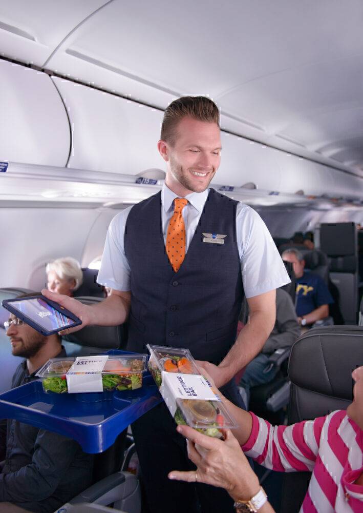 JetBlue Flight Attendant Moves Through The Cabin Offering Refreshments