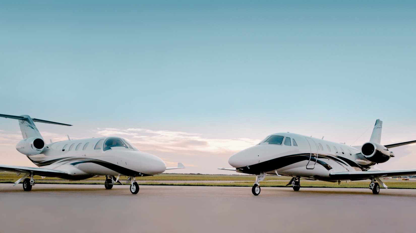 Two Cessna Citation series aircraft parked on an airport apron.