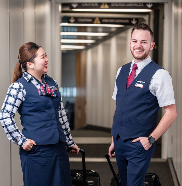 Two American Airlines Flight attendants standing in the jet bridge.
