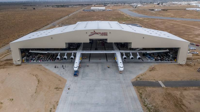 The Stratolaunch aircraft parked halfway inside of a hangar.
