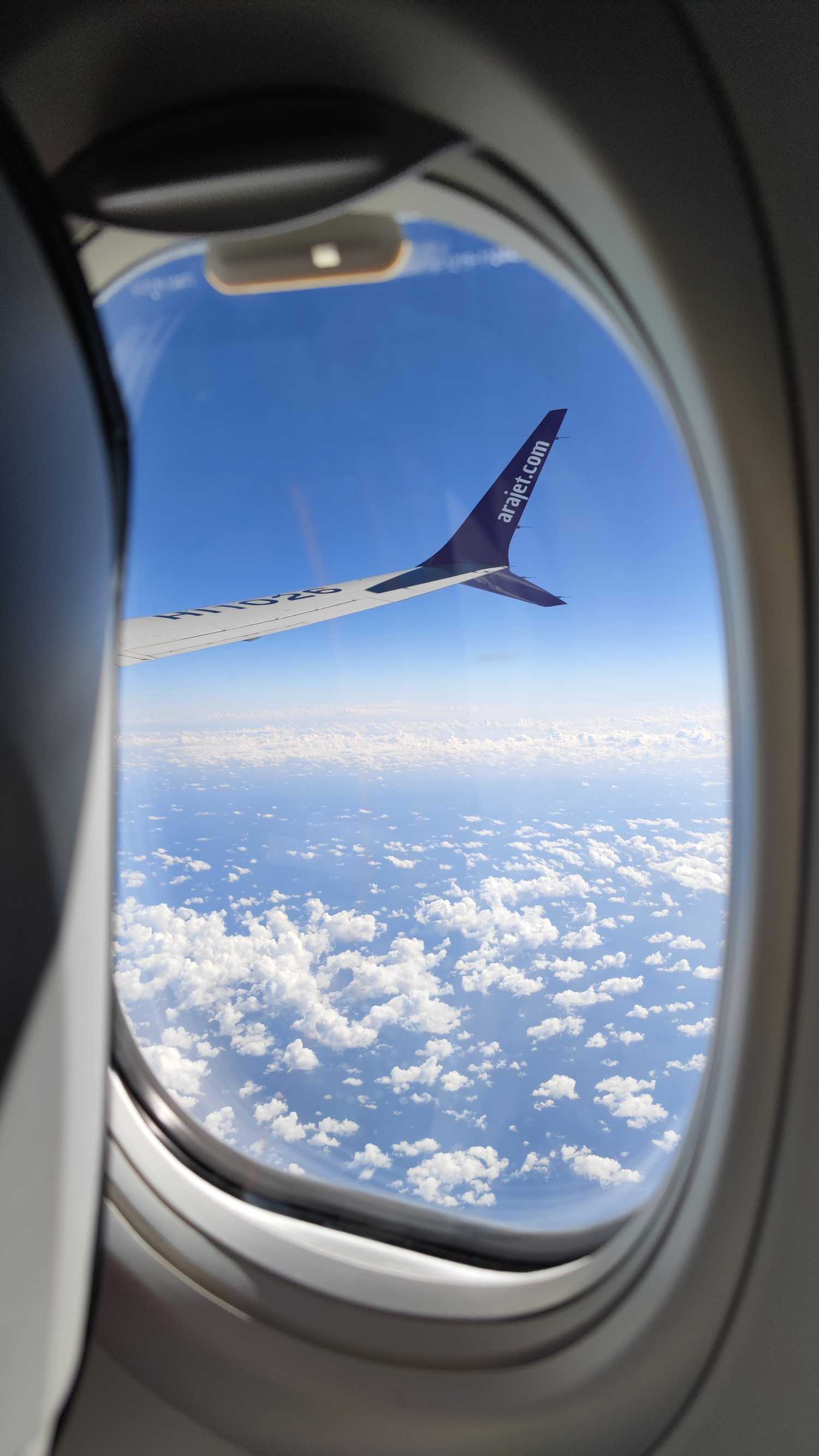 A view of a wingtip of an Arajet Boeing 737 MAX 8 aircraft from a window while in the air-1