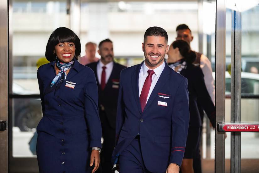 A few flight attendants walking into an airport.