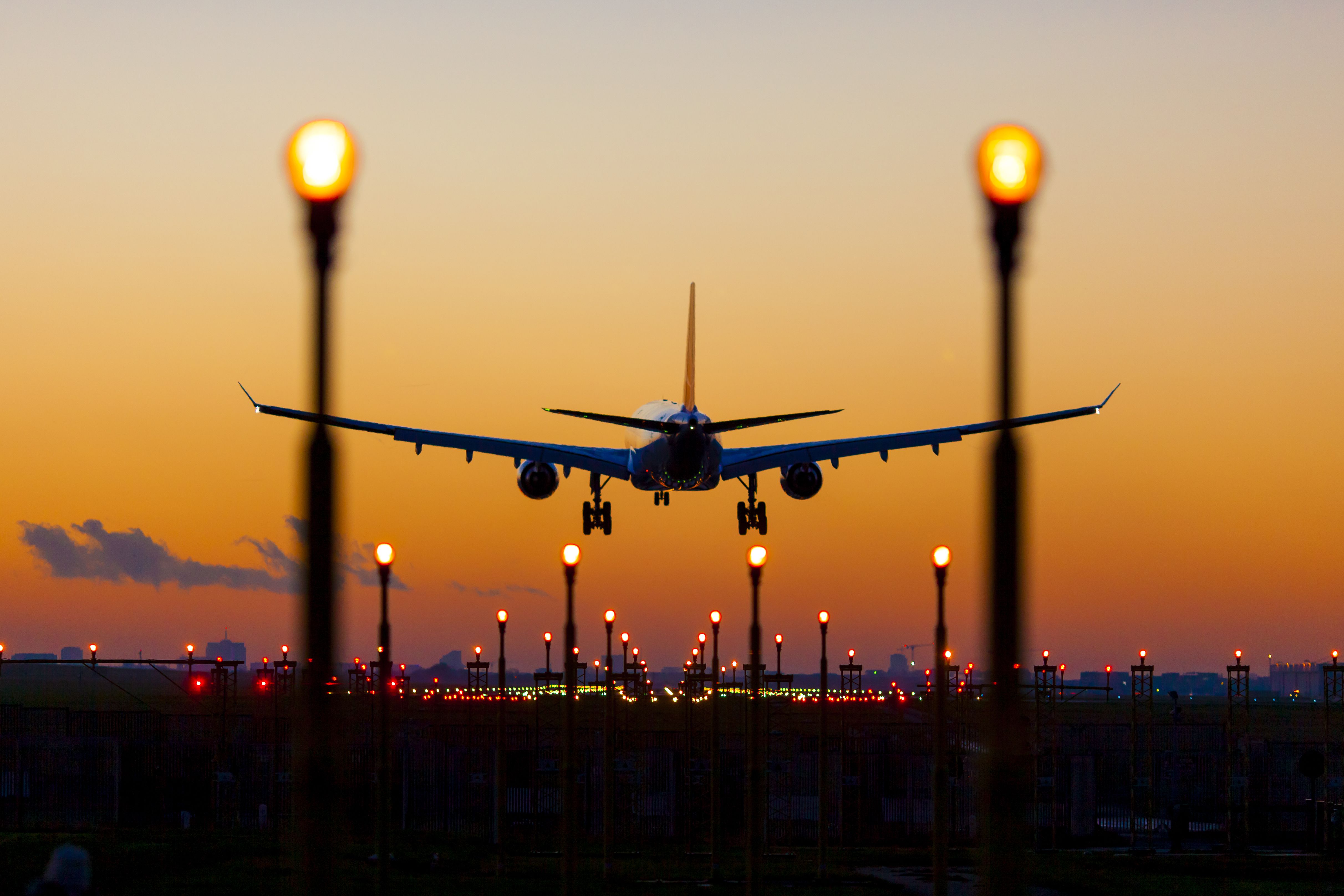 plane landing on runway at dusk