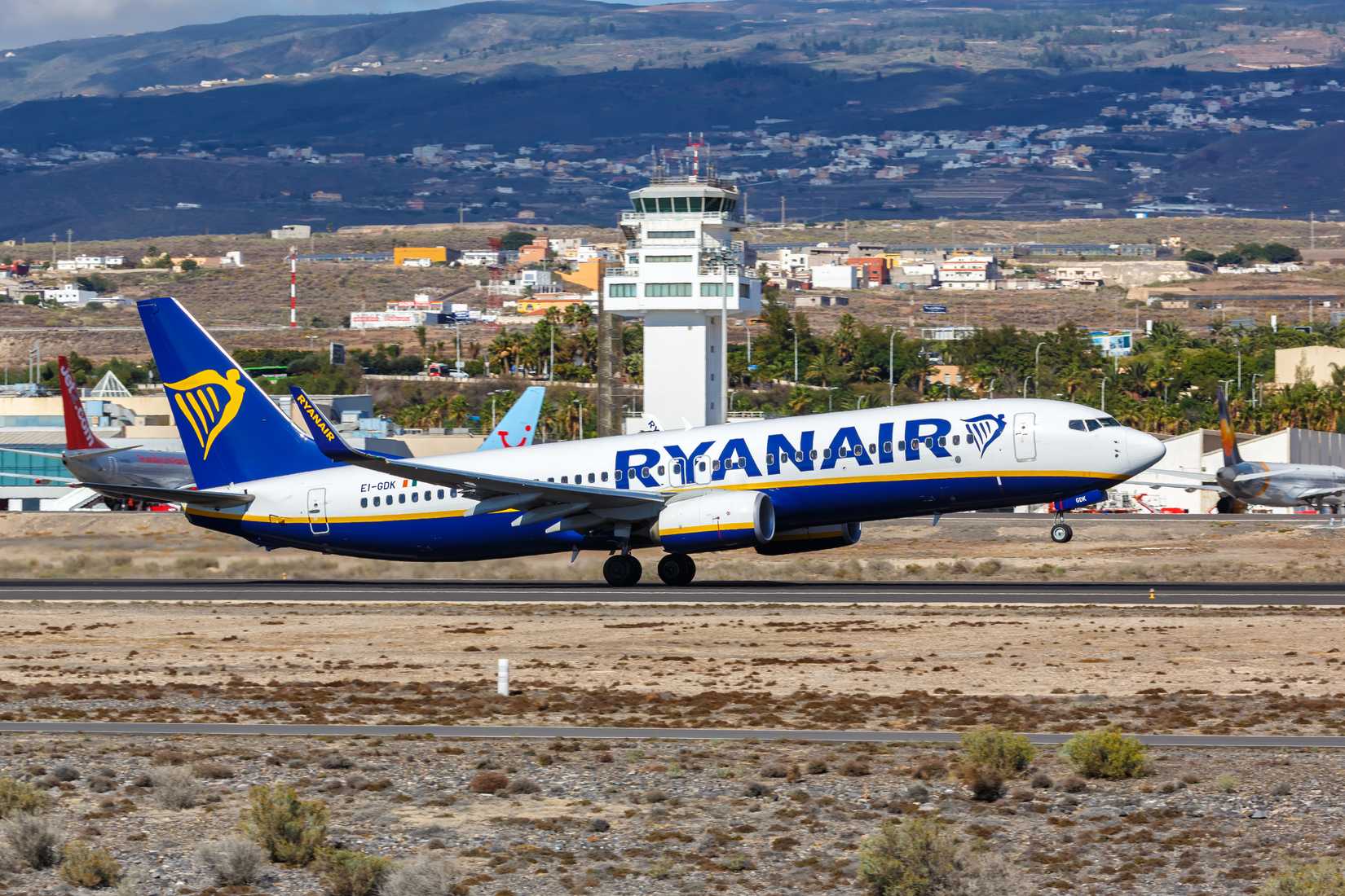 A  Ryanair Boeing 737 taking off from Tenerife South Airport with the ATC tower seen in the background.