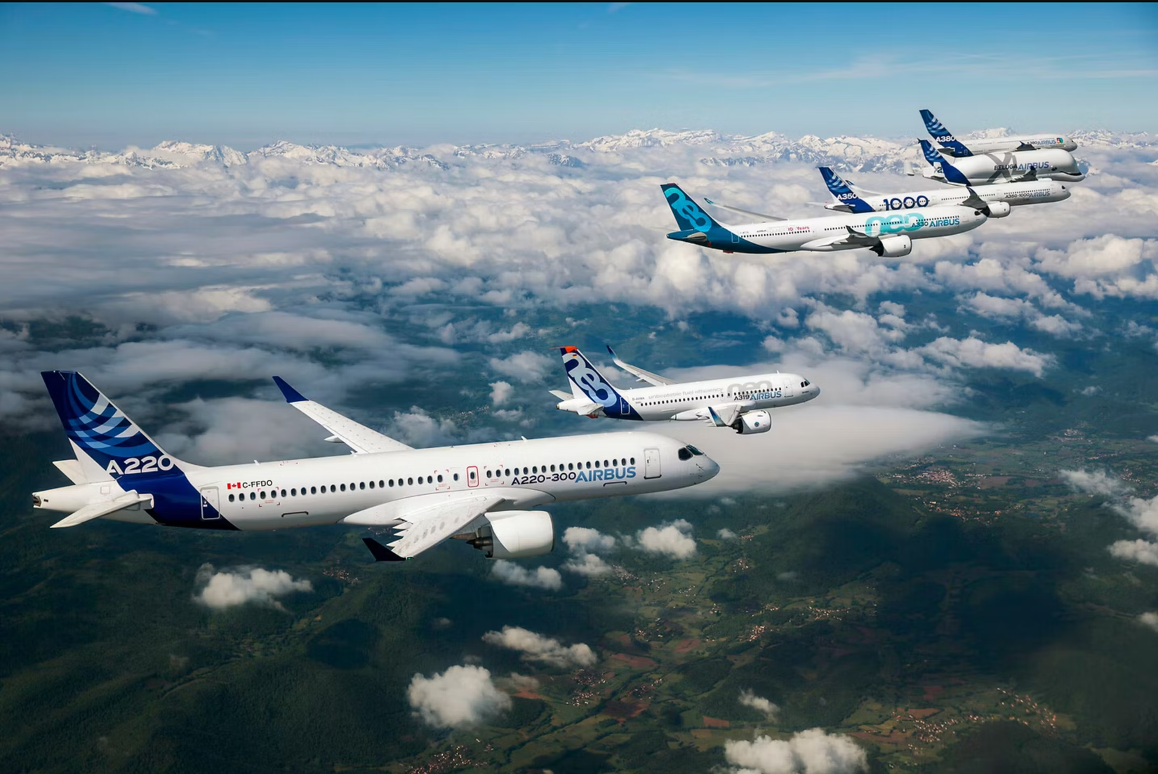 Many Airbus aircraft flying together over land.