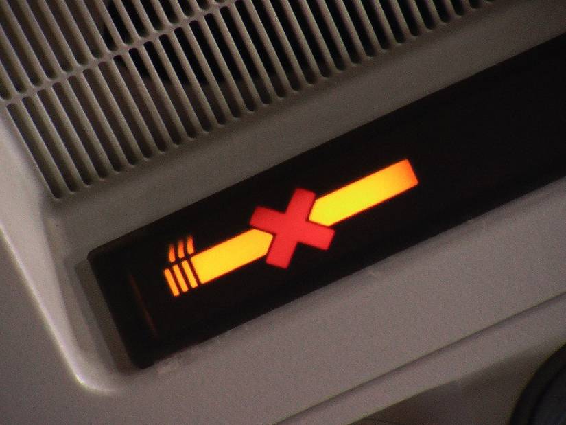 A no-smoking light illuminated inside a passenger cabin.