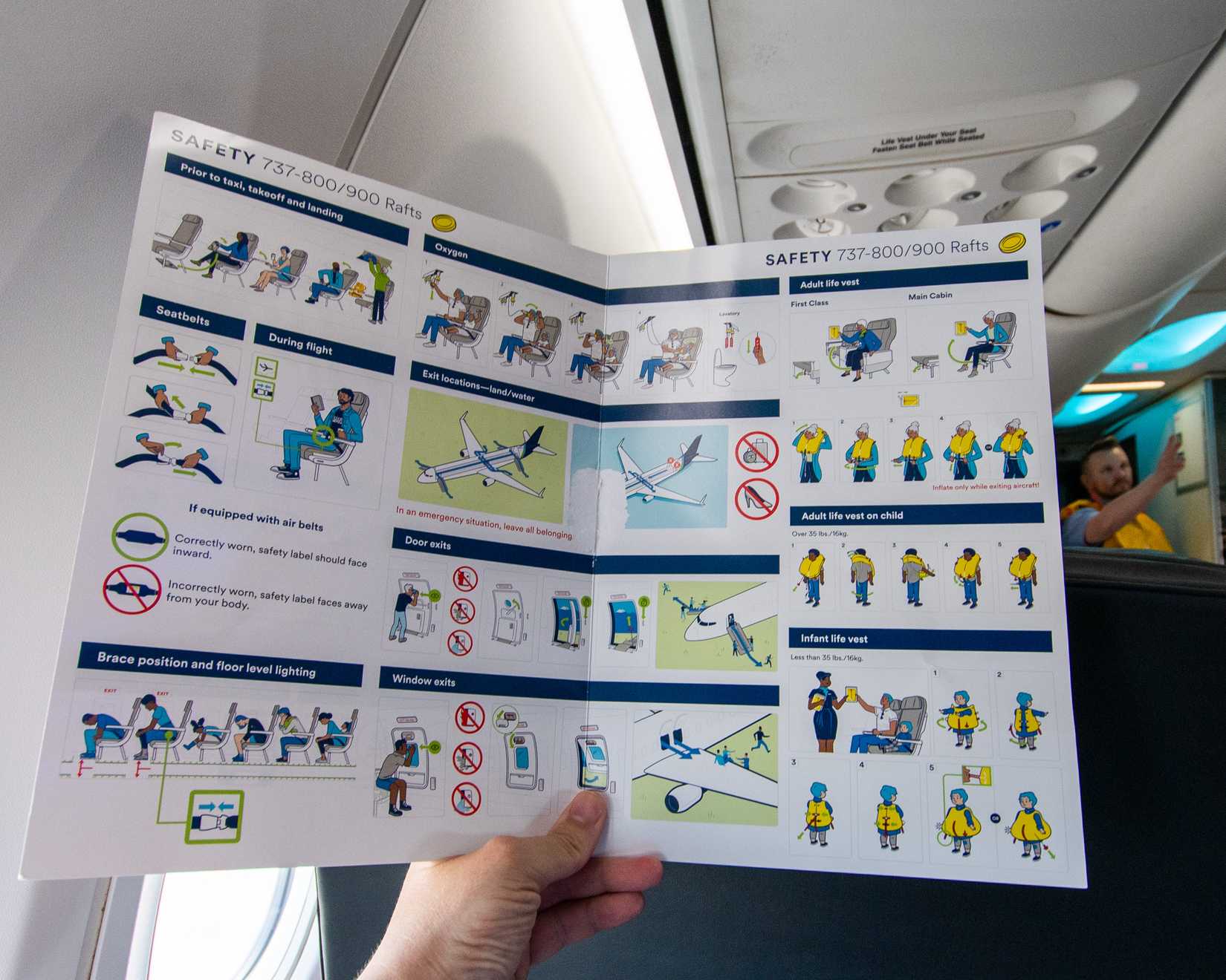 A person holding an aircraft Safety Card.