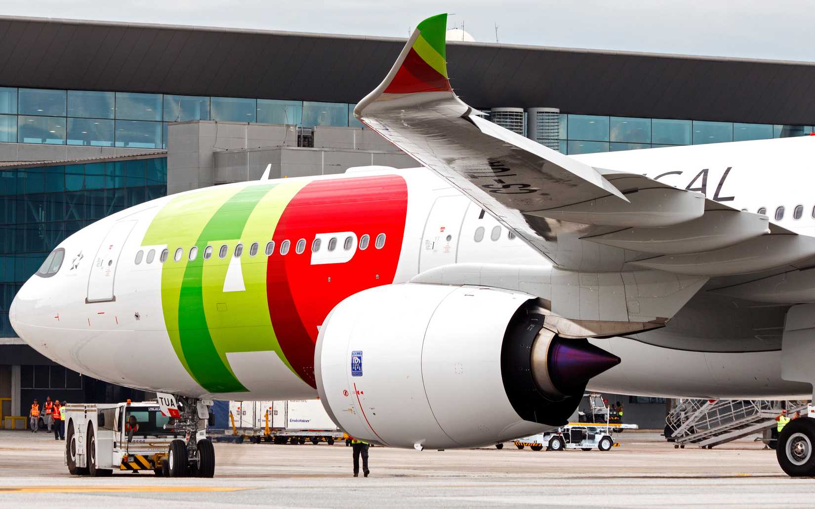 A TAP Air Portugal A330neo parked at an airport.