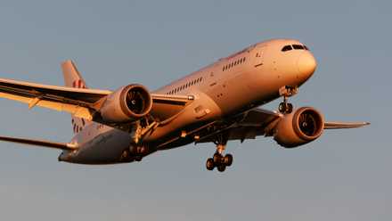 A Comlux Aruba Boeing 787-8 Dreamliner flying in the sky.