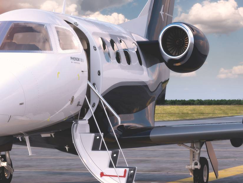 An Embraer Phenom 100 EV parked on an airport apron.