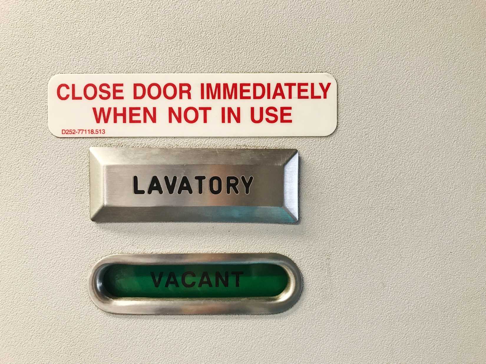 A closeup photo of some signage on an aircraft lavatory door.