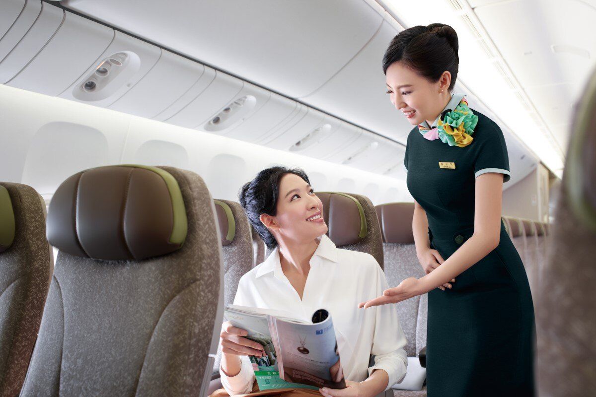 An EVA Air flight attendant talking with a passenger.