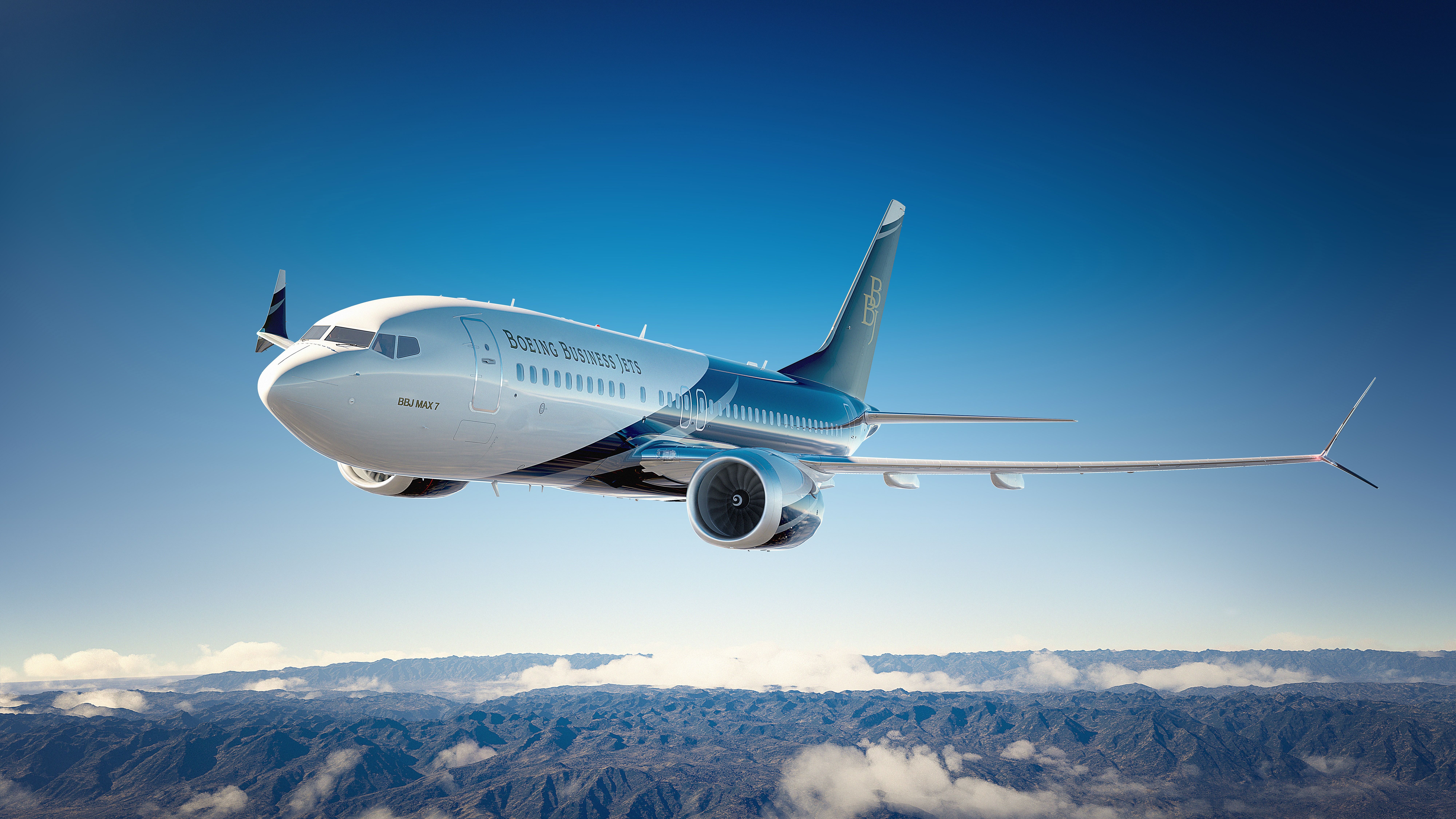 A BBJ MAX 7 flying above the clouds.