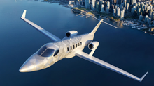 A HondaJet 2600 flying near a coastal city.