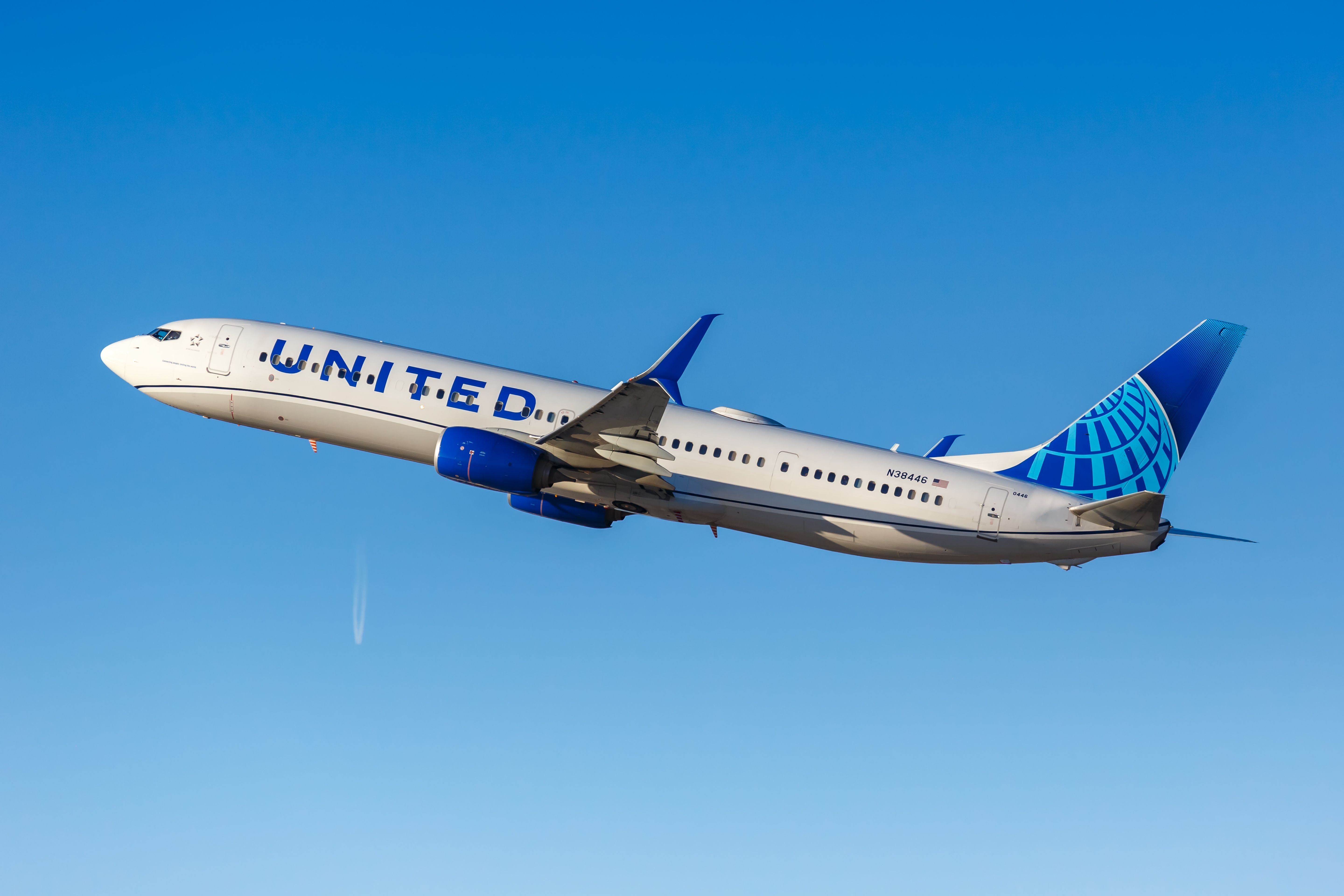 A United Airlines Boeing 737-900ER flying in the sky.