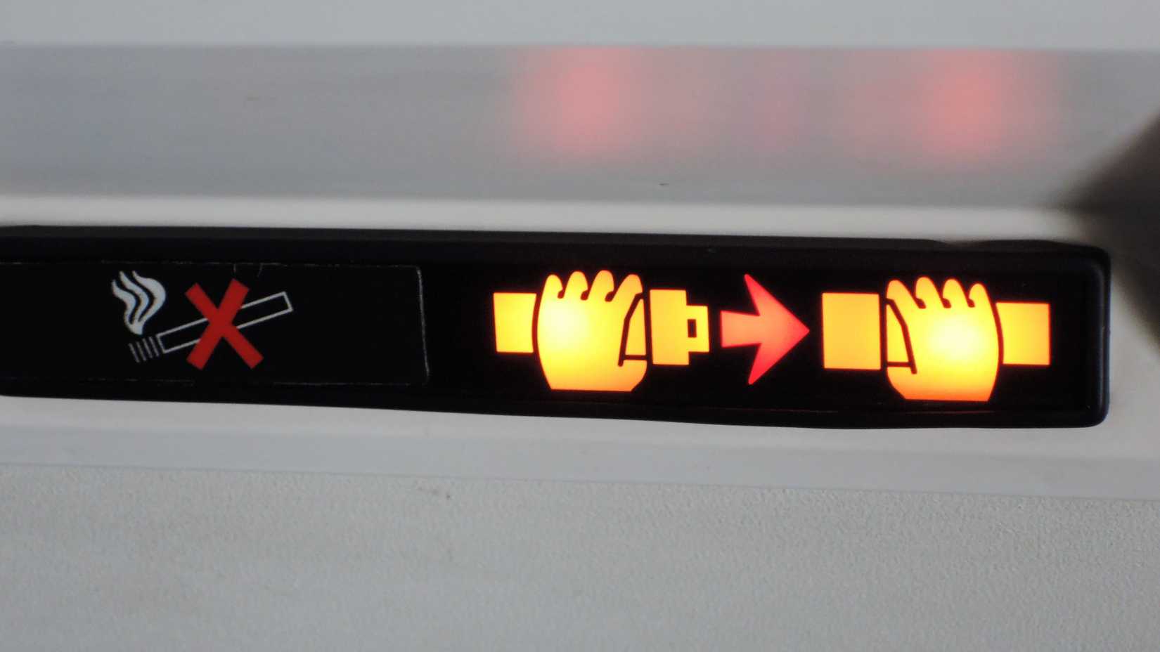 An illuminated seatbelt sign in an aircraft.