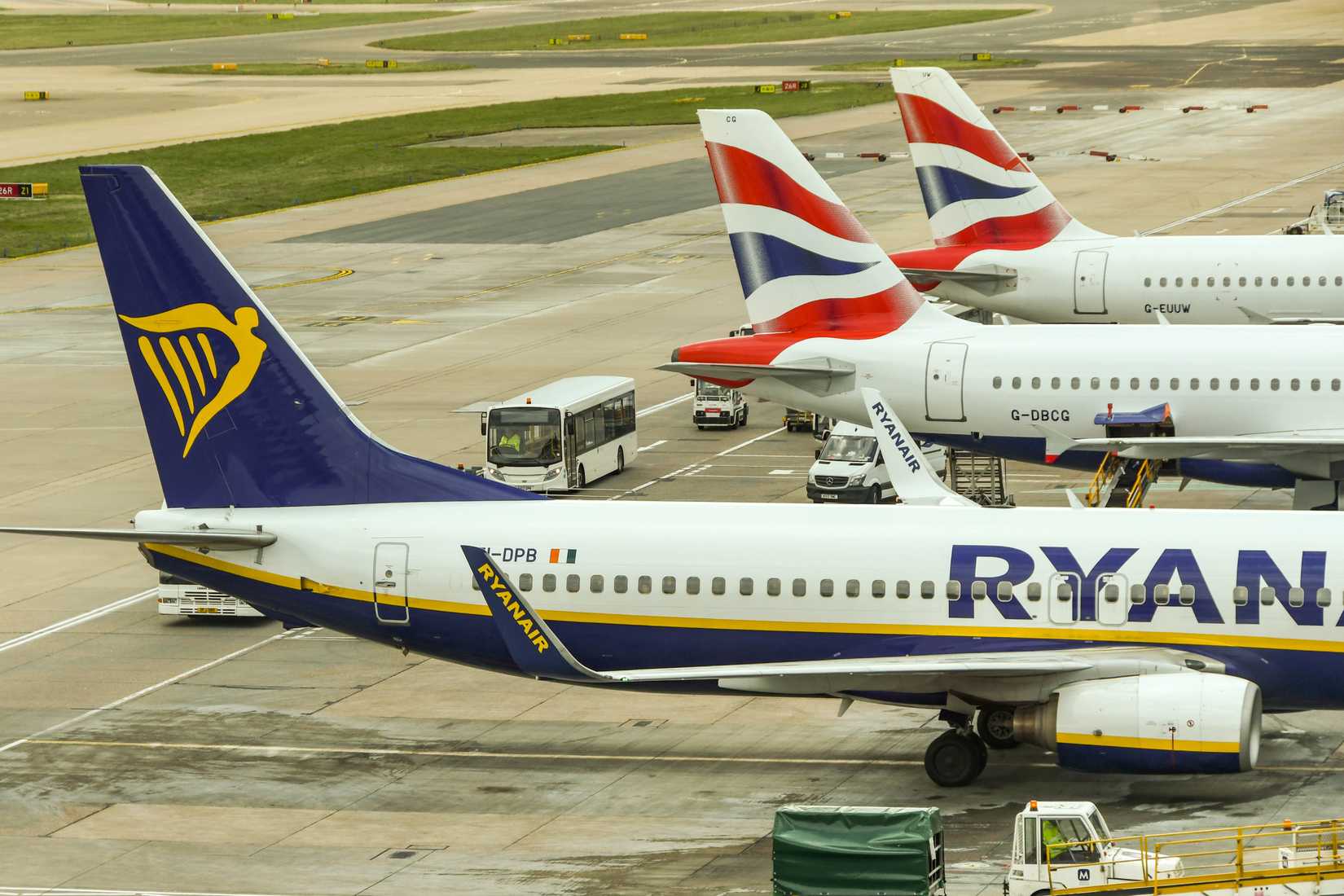 A Ryanair Boeing 737 parked alongside two British Airways jets at London Gatwick Airport.