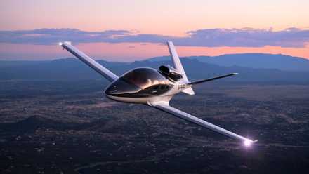 A Cirrus SF50 Vision Jet flying over a city.