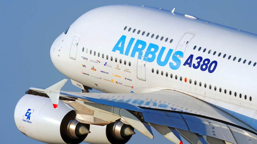 A closeup of an Airbus A380 in house livery flying in the sky.