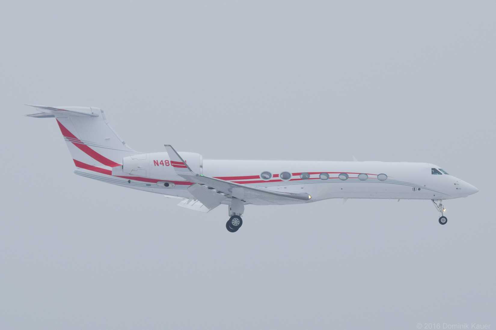 A Coca-Cola Gulfstream G550 flying in the clouds.