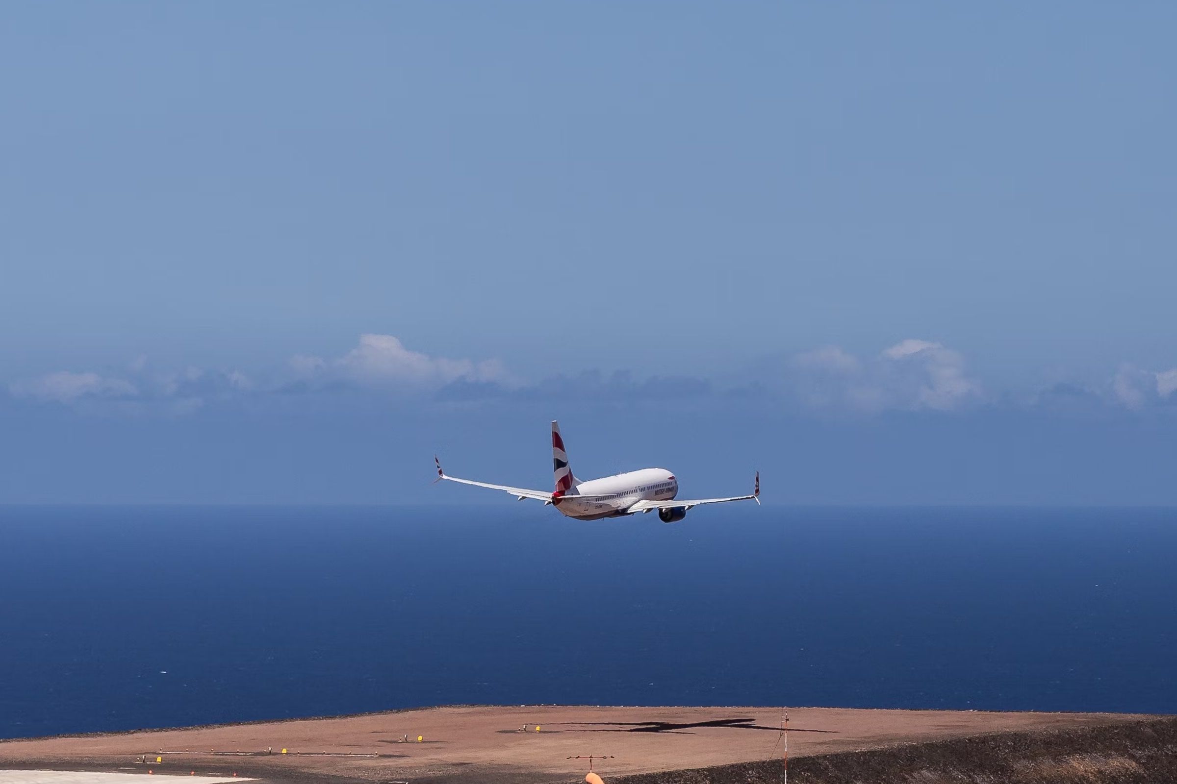 A Boeing 737-800 in British Airways livery taking off from Saint Helena Airport.