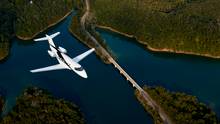 The Pilatus PC-24 Super Versatile Jet flying over water.