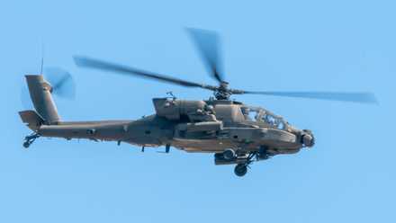 A Boeing AH-64 Apache flying in the sky.