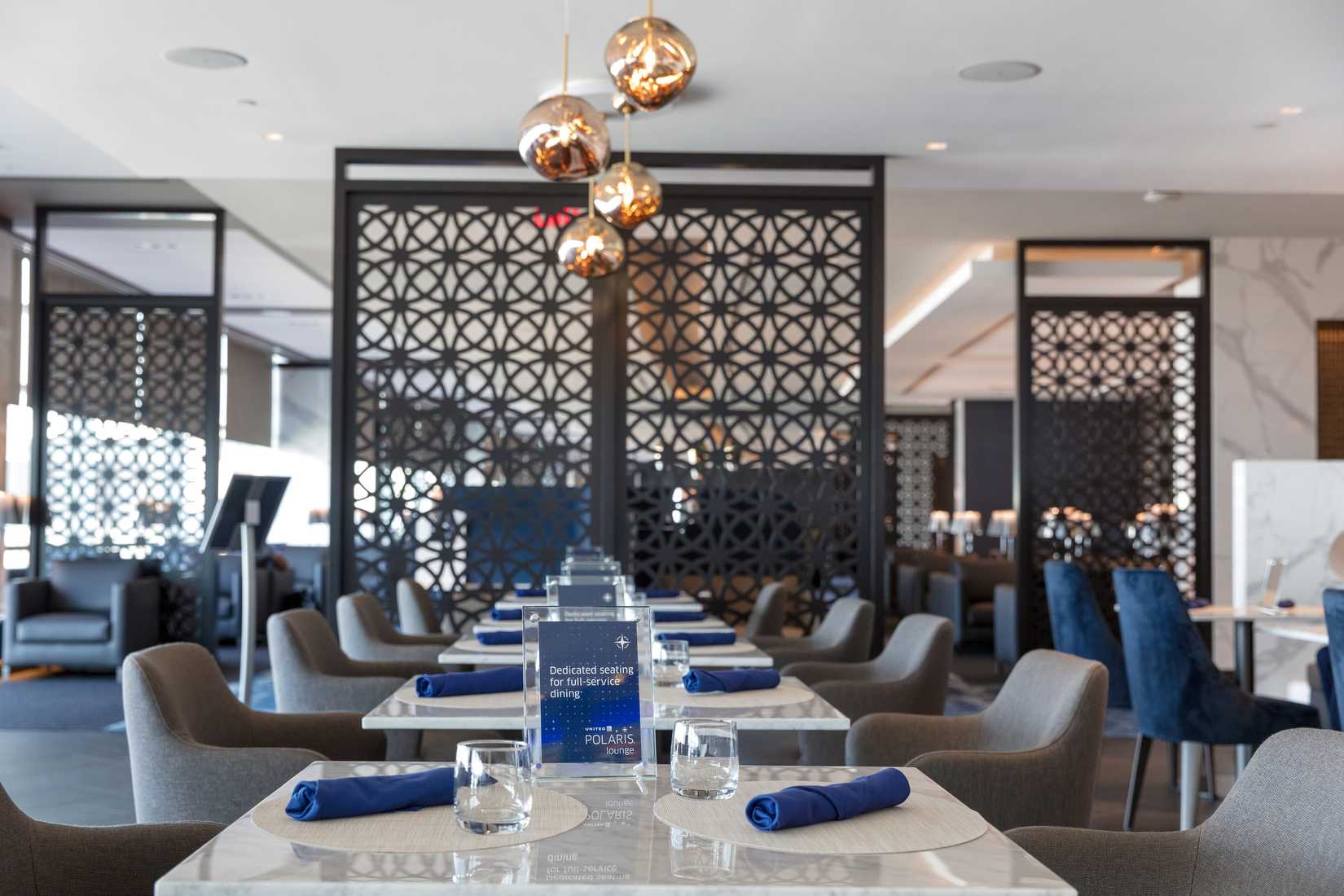 Tables inside the United Polaris Lounge at Newark Liberty Airport.