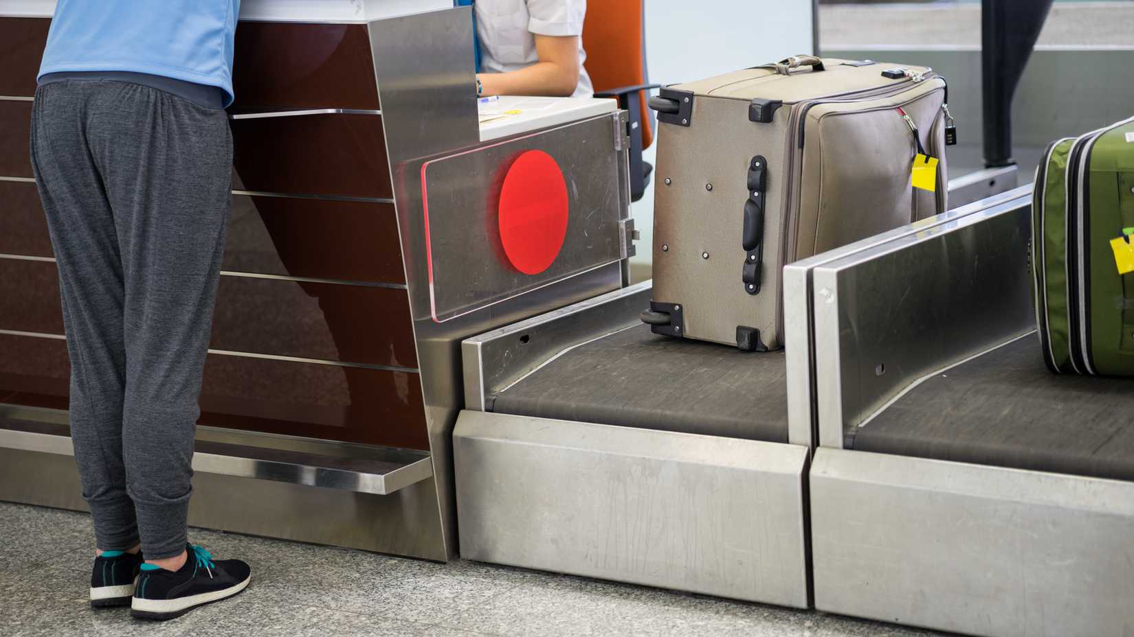 A piece of luggage being weighed at an airport check in desk.