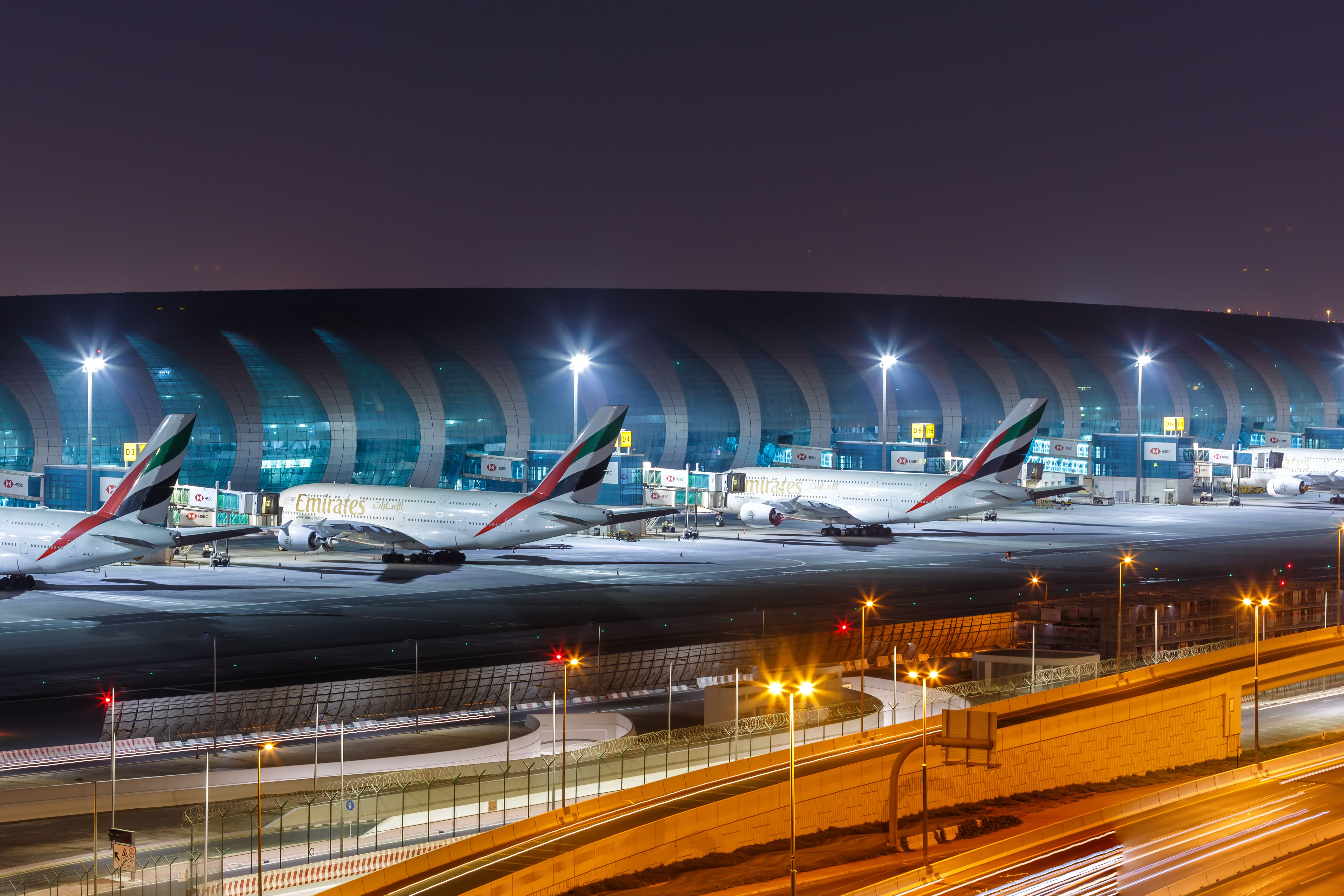 Several Emirates Airbus A380s parked at Dubai International Airport.