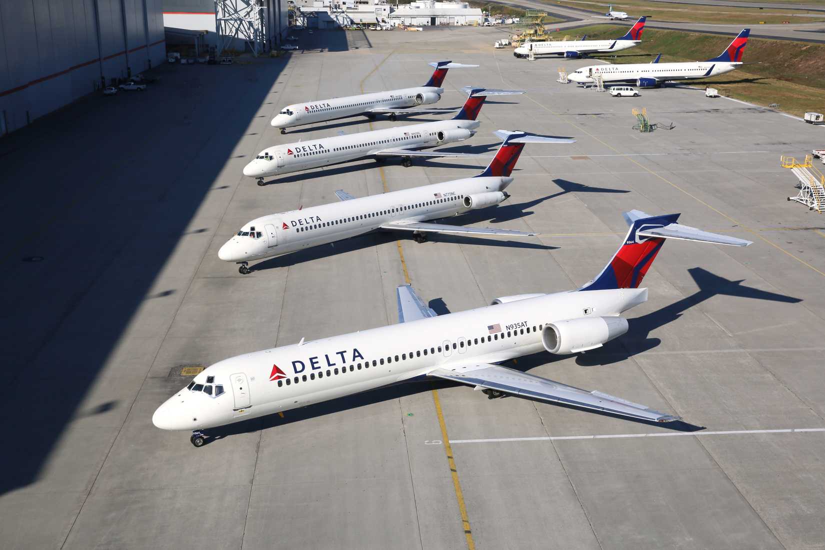 Several Delta Air Lines Boeing 717s parked on an airport apron.