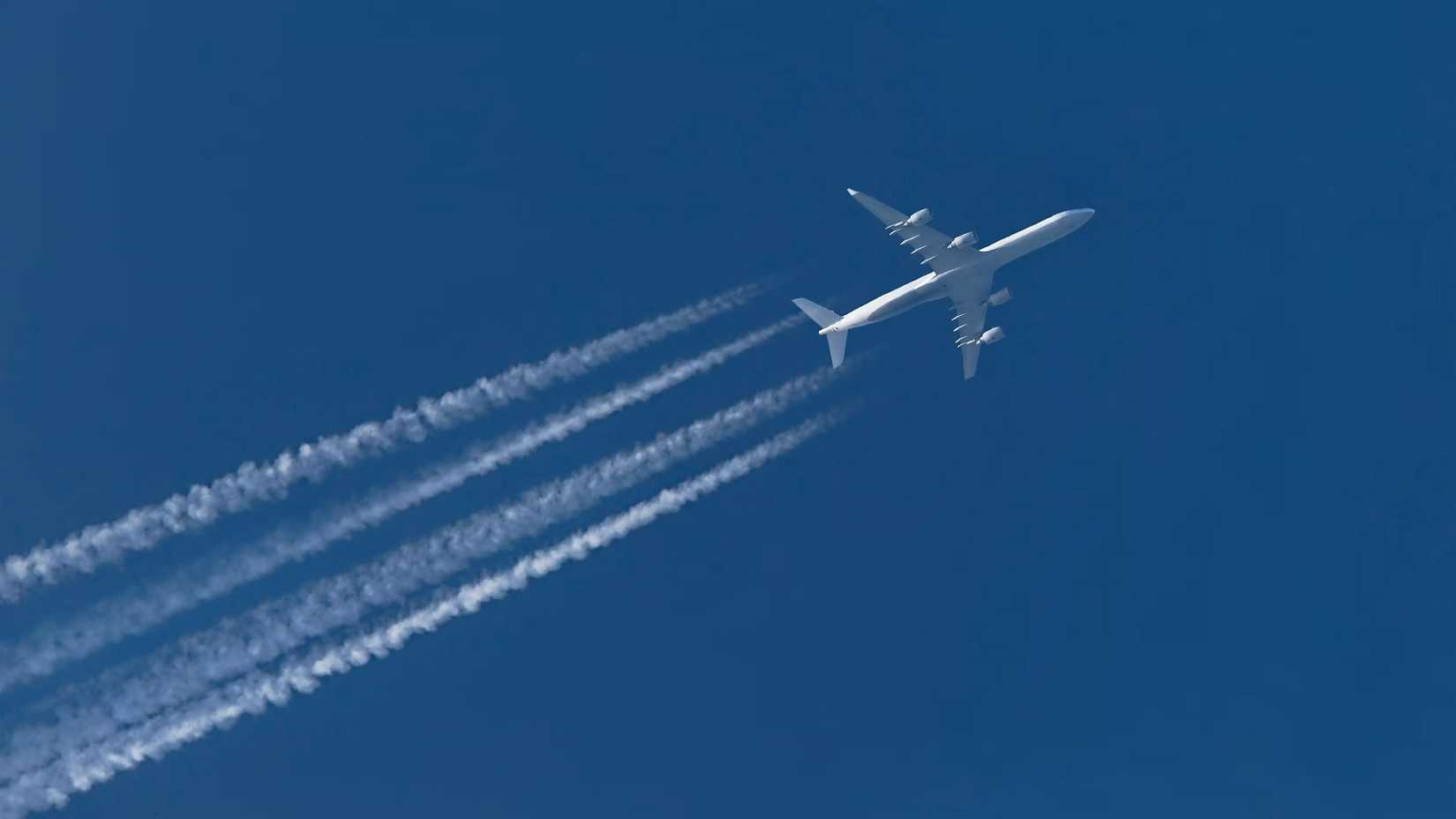 quadjet with contrails in the sky