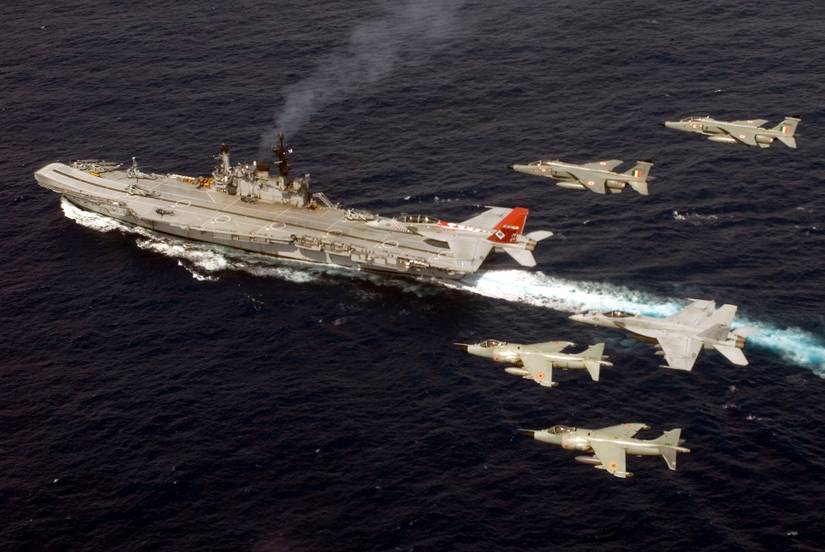 Vários caças de ataque SEPECAT Jaguar da Força Aérea Indiana sobrevoando um porta-aviões.