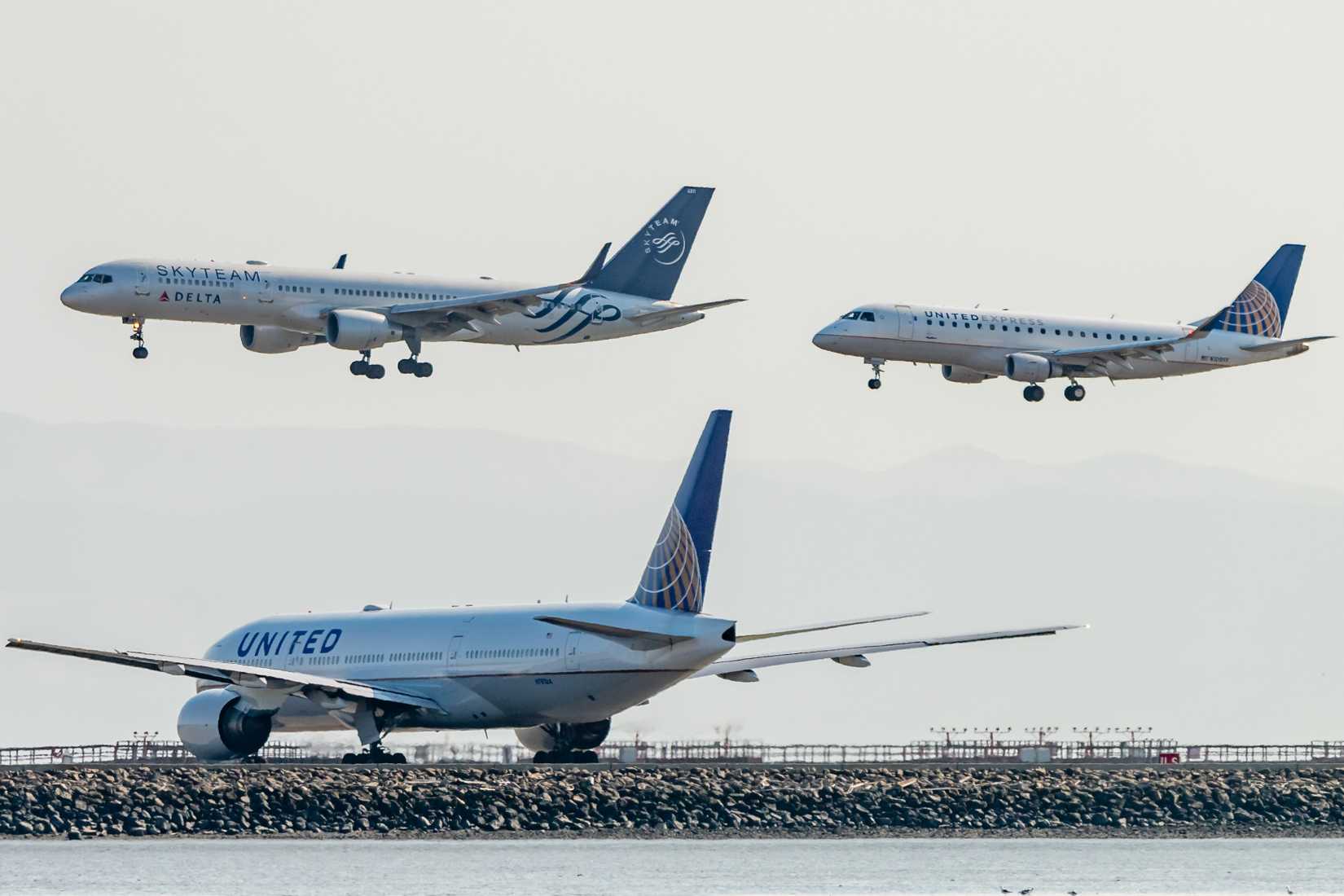 Delta Air Lines and United Airlines aircraft landing together on parallel runways.