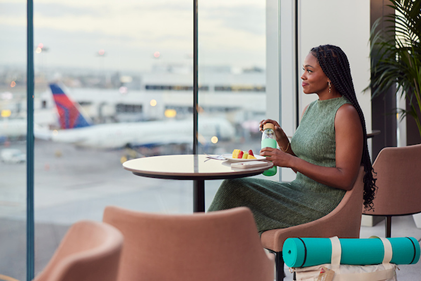 A passenger sitting in the Delta Sky Club lounge at Hartsfield Jackson Atlanta International Airport.