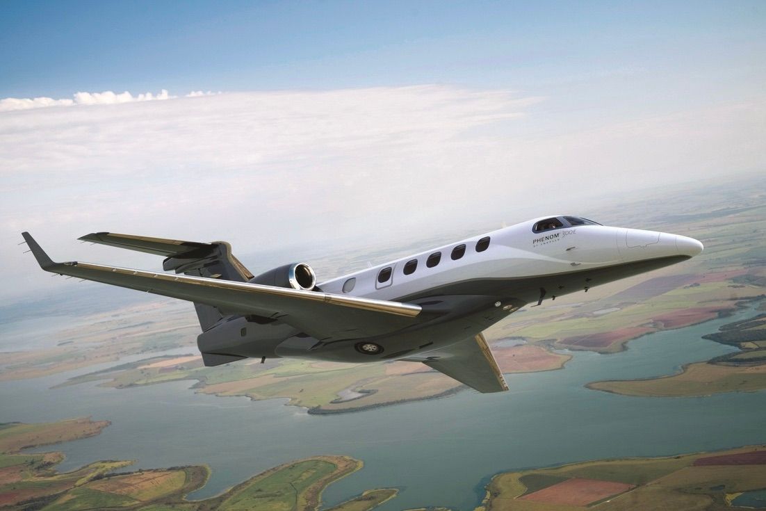 An Embraer Phenom 300EX flying in the sky.