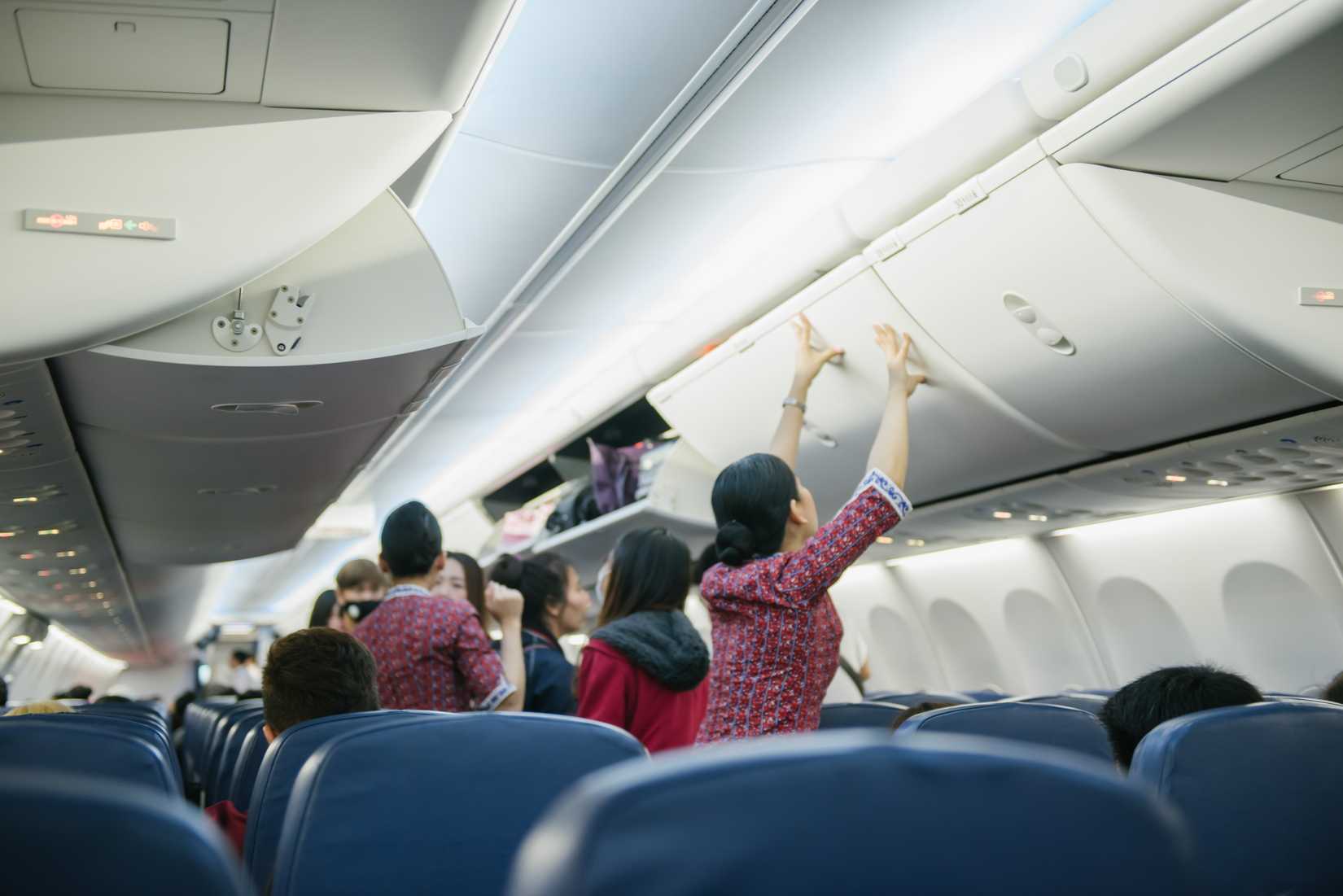 Cabin crew  shutting overhead lockers