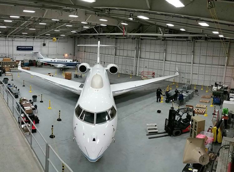 A Bombardier Global Express parekd in a large hangar.