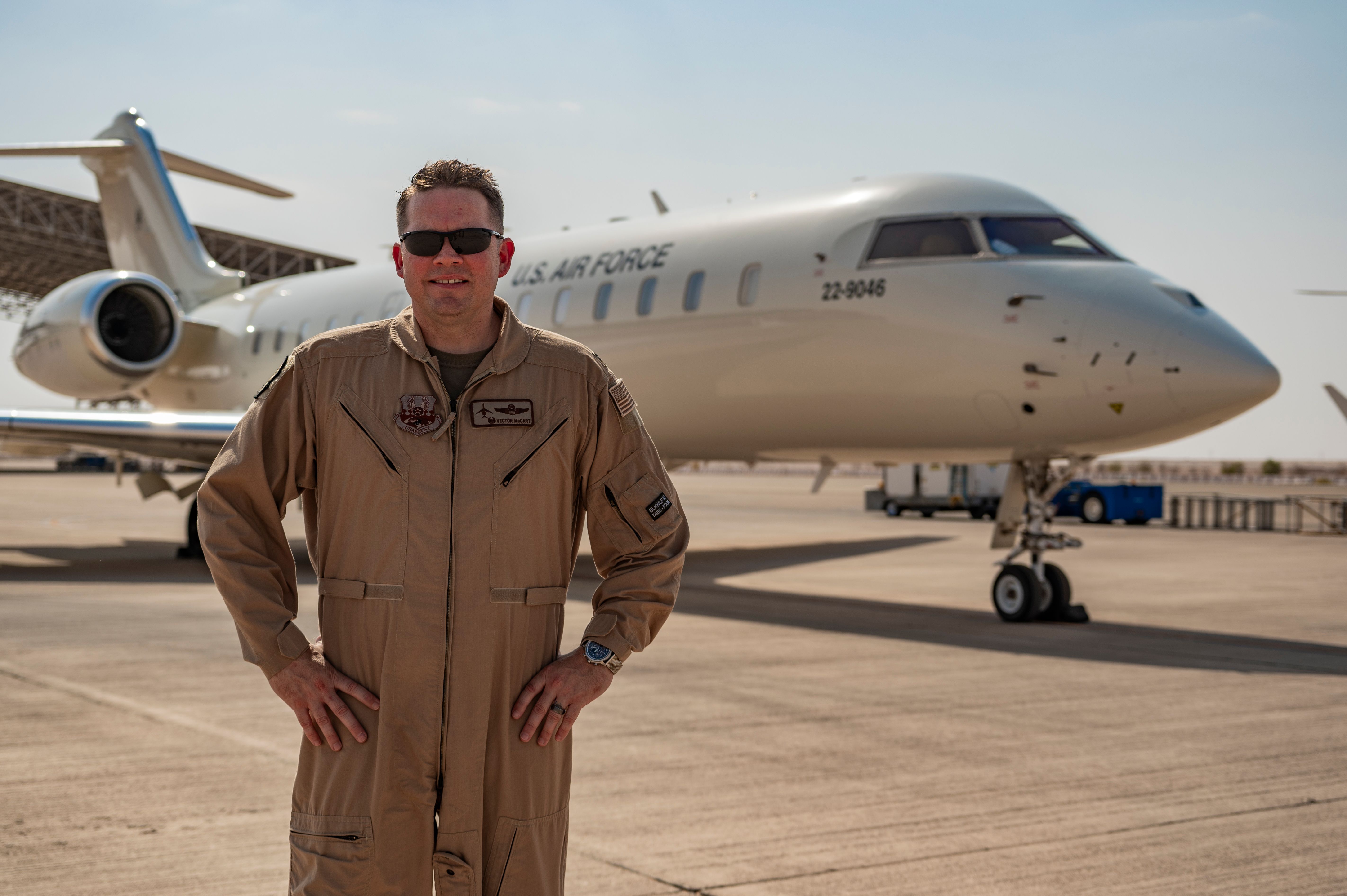 Photo of USAF Lt. Col. McCart posing in front of an E-11A BACN aircraft