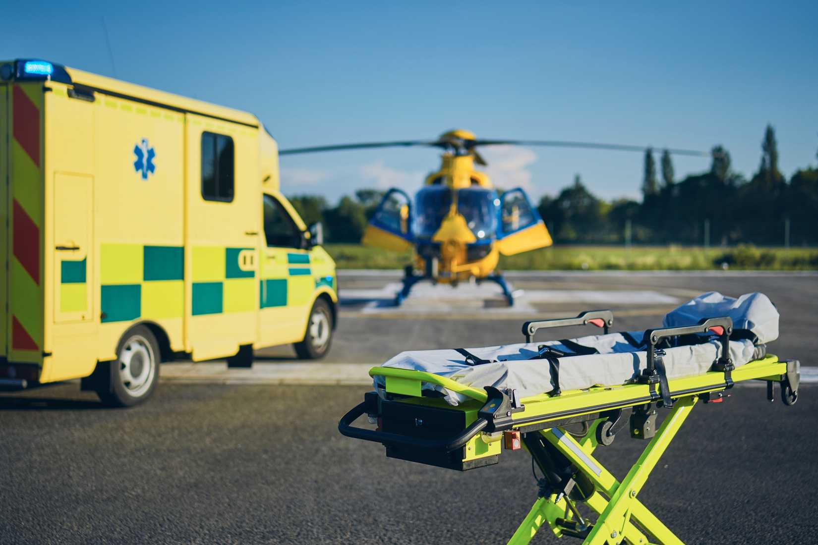 Stretcher against ambulance car and helicopter of emergency medical service.