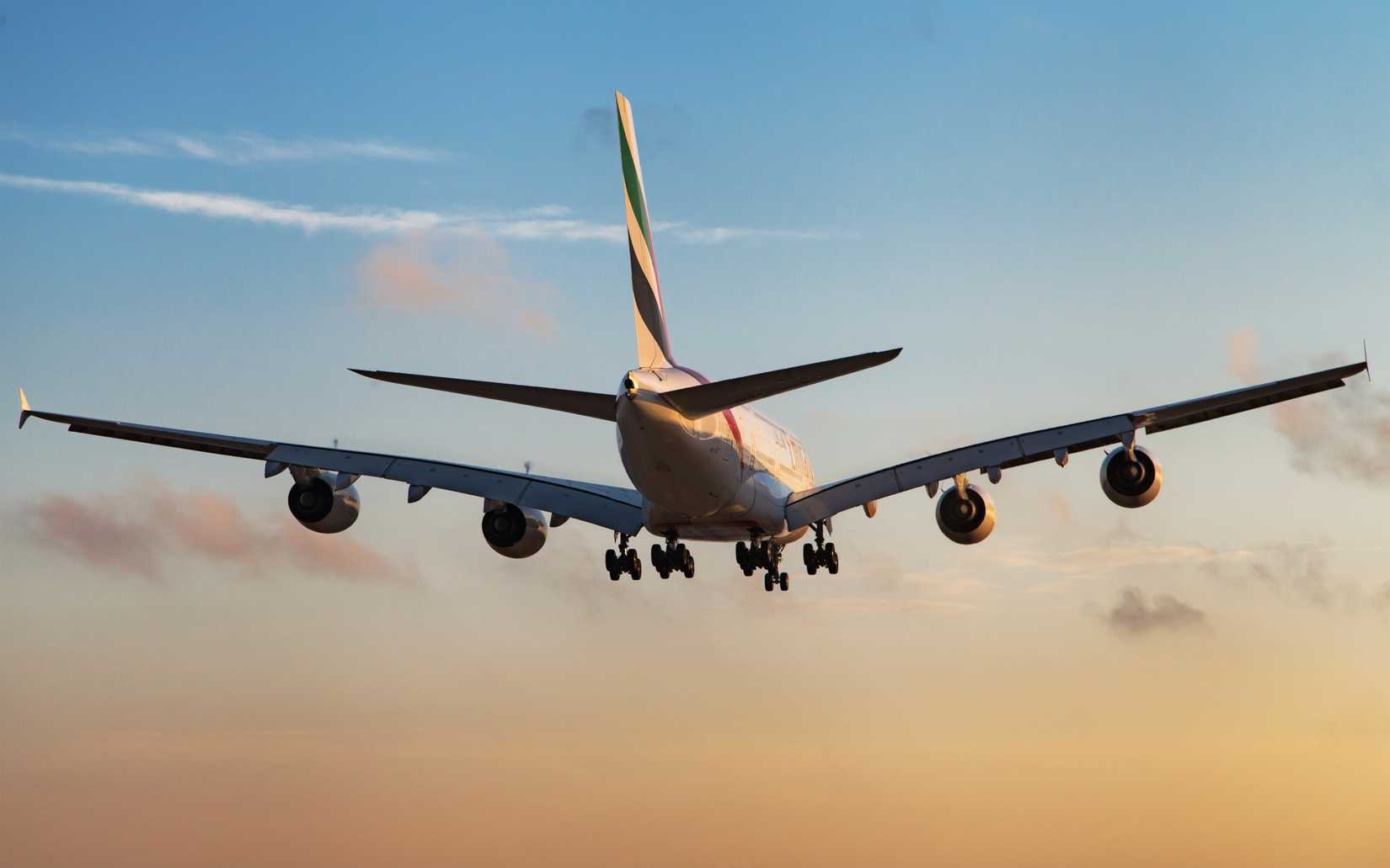 Rear view of an Emirates Airbus A380-800 landing at sunset at El Prat Airport in Barcelona, Spain.