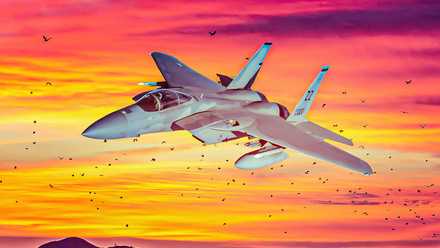 F-15 flying with sunset in the background.