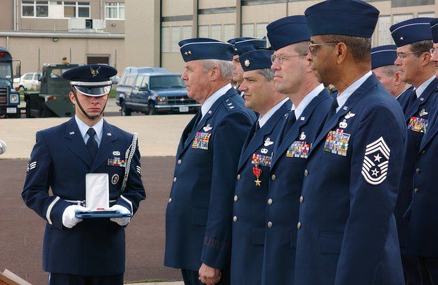 US Air Force (USAF) SENIOR AIRMAN (SRA) Alex Sutherland, holds a Bronze Star to be awarded to CHIEF MASTER Sergeant (CMSGT) Barford, second from right, by Major General (MGEN) James Skiff, second from left, the Deputy Adjutant General (DAGEN) for the Pennsylvania Air National Guard (ANG). Also being awarded a Bronze Star is Lieutenant Colonel (LCOL) Tony Carrelli at the Willow Grove Air Reserve Station (ARS), Willow Grove, Pennsylvania (PA). At right is the Command CHIEF MASTER (CCM) Sergeant CMSGT Louis Boykin