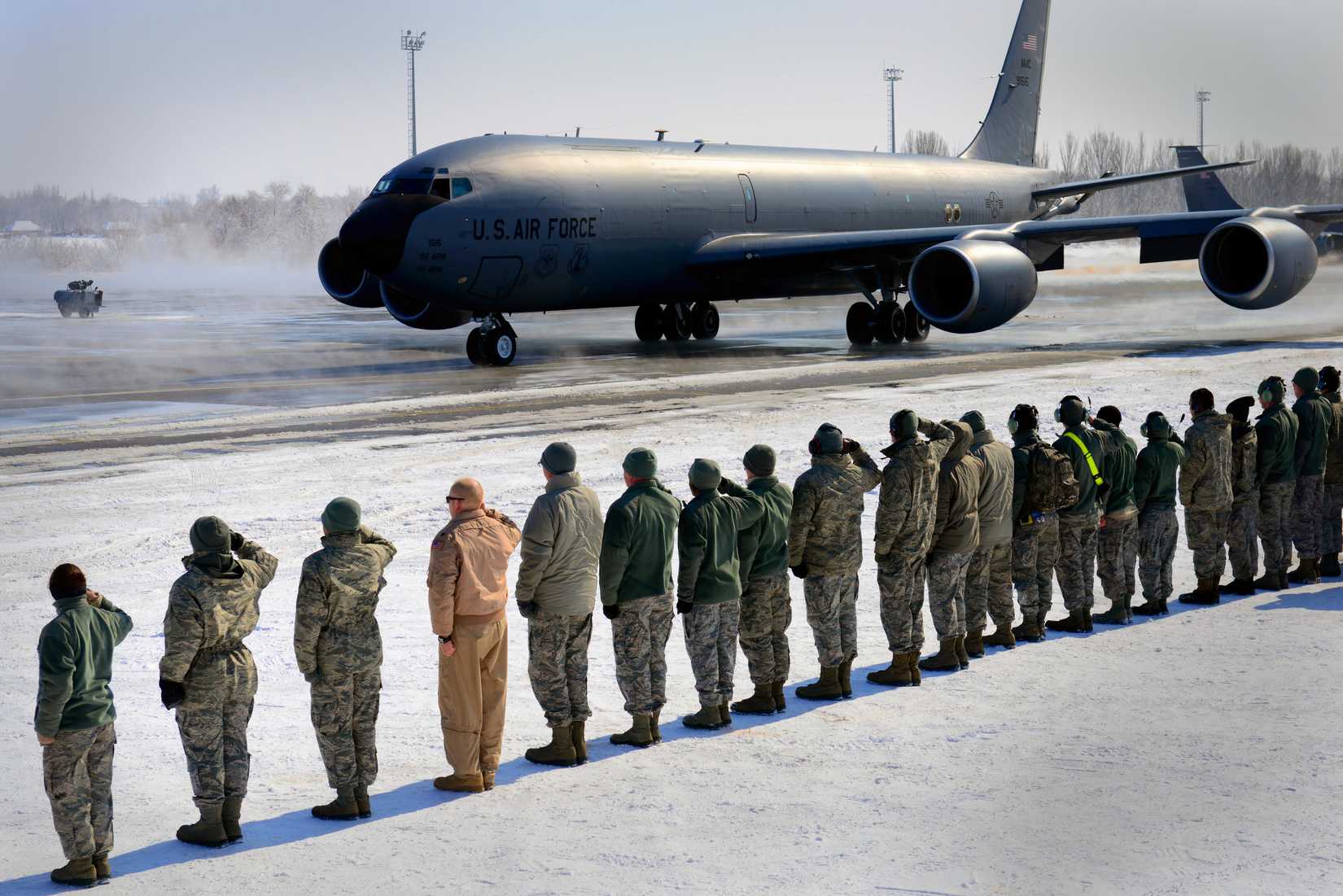 KC-135 taxiing, with USAF personnel saluting the pilots and crew of the aircraft.