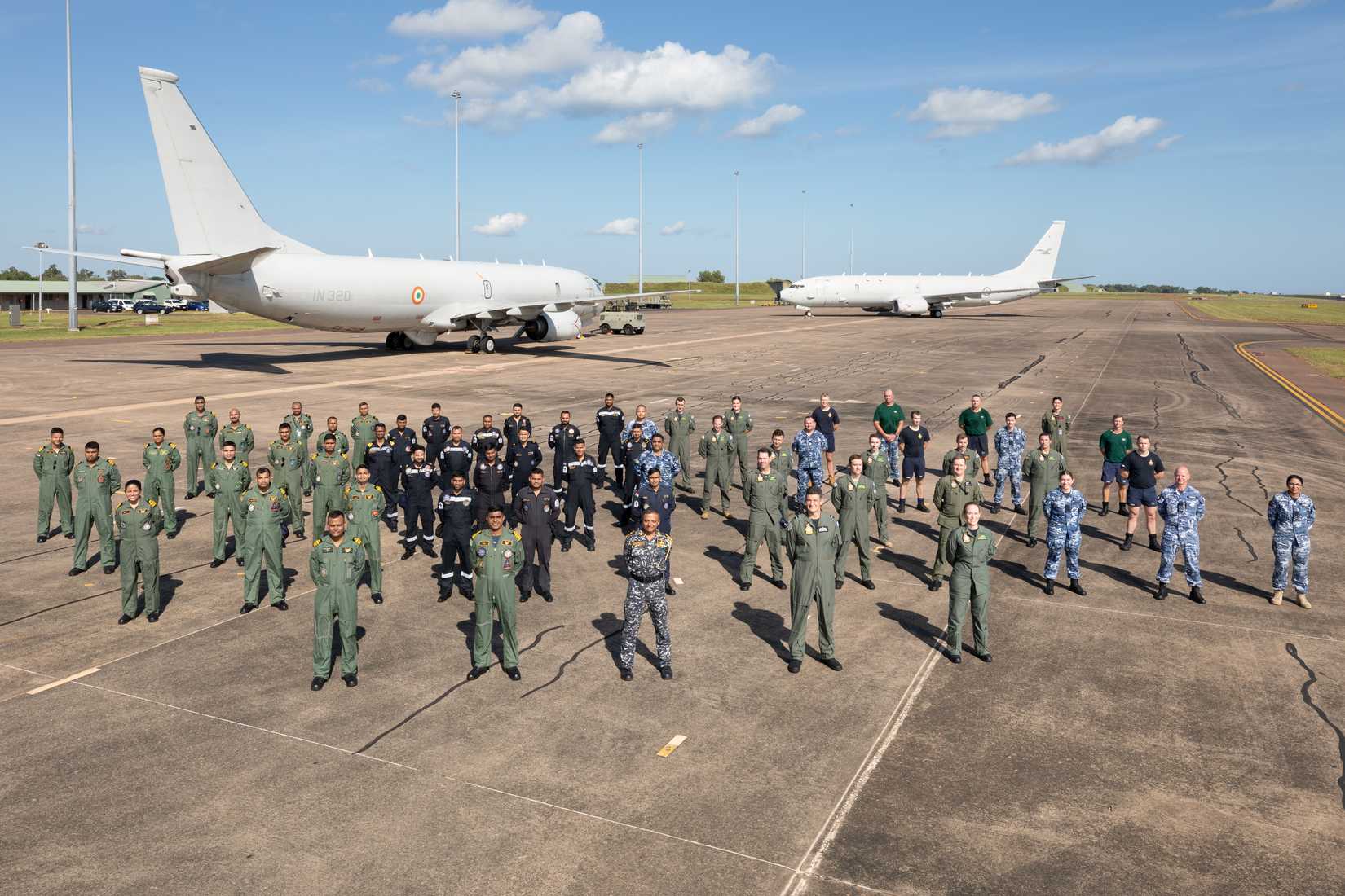 Royal Australian Air Force and Indian Navy aircrews and maintenance crews from the Indian Navy P-8I Neptune (left) and RAAF P-8A Poseidon aircraft at RAAF Base Darwin in the Northern Territory.