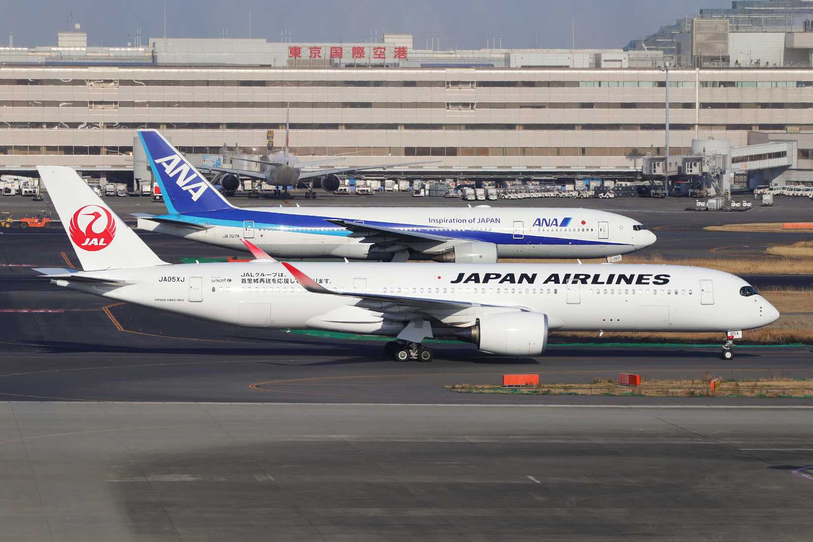 Japan Airlines Airbus A350-900 and ANA Boeing 777-200 at Tokyo Haneda Airport HND shutterstock_1692420436