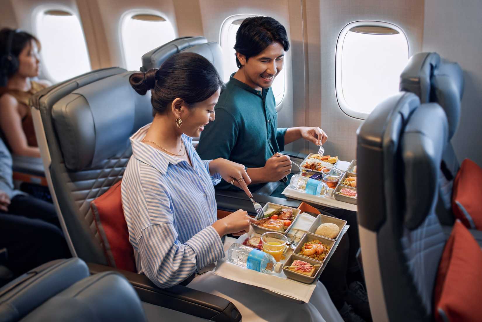 A couple in Singapore Airlines premium economy enjoy their meals