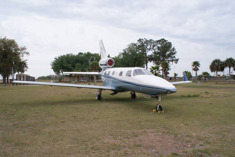 Blue and white PiperJet sitting on grass.