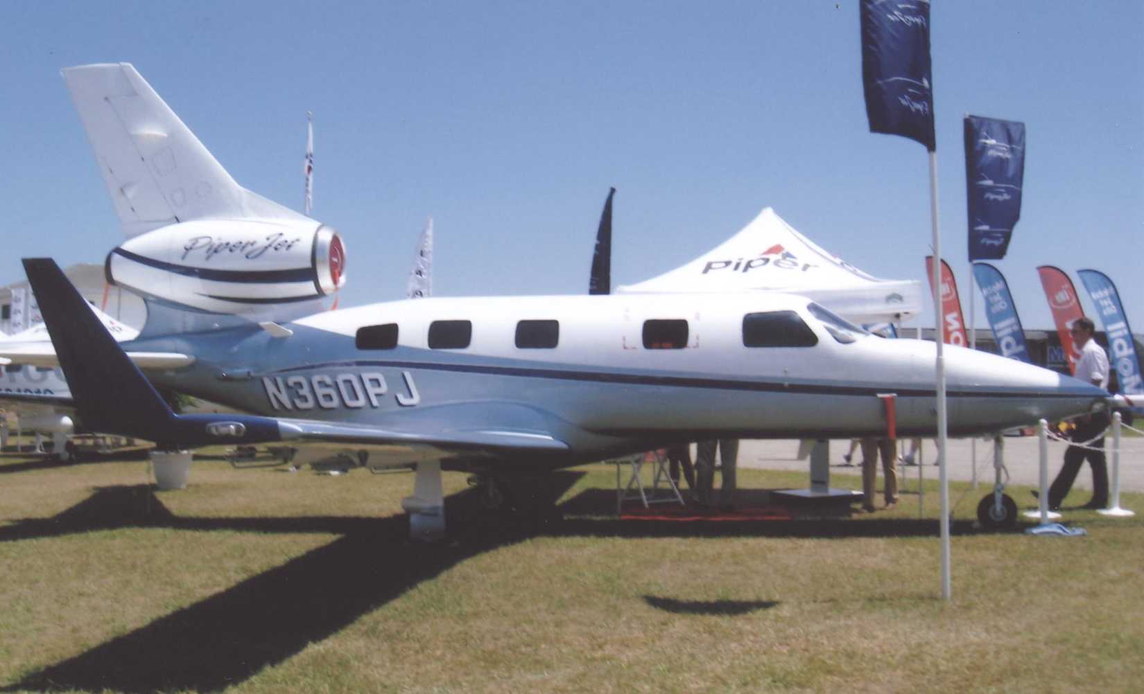 PiperJet sitting on grass at an air show.